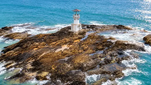 Sonniger Strand von Khao Lak mit Leuchtturm an der Küste von Phang Nga